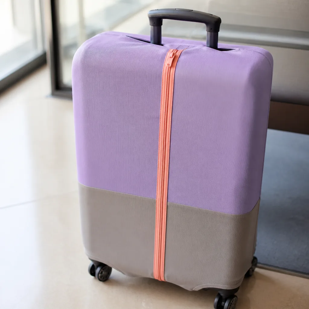 suitcase with a two tone protective cover and a contrasting colored zipper, close-up product photography, no faces